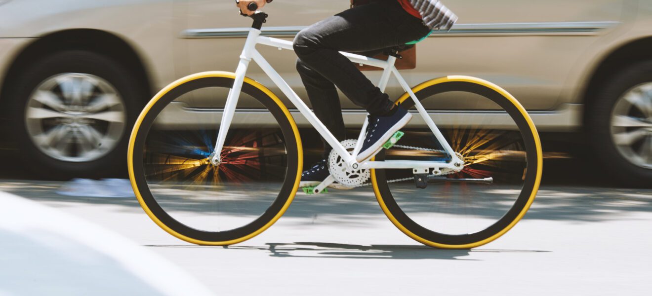 Fahrrad fährt eng neben Auto auf der Straße