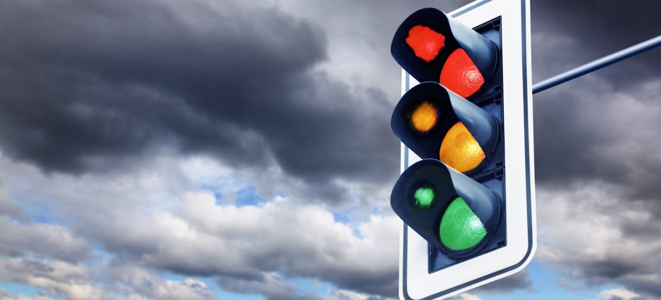 Die leuchtende Ampel vor bewölktem Himmel