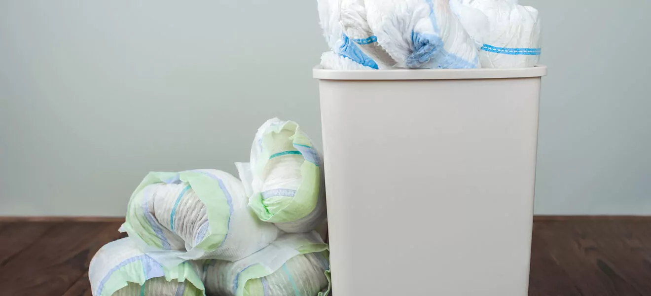 Volle Einwegwindeln liegen im Restmüll oder daneben