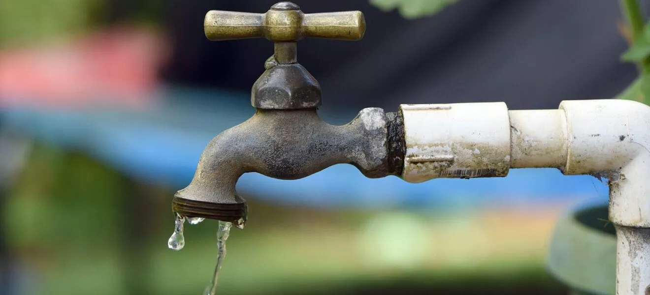 Tropfender Wasserhahn als Symbol für Wasserknappheit in Deutschland