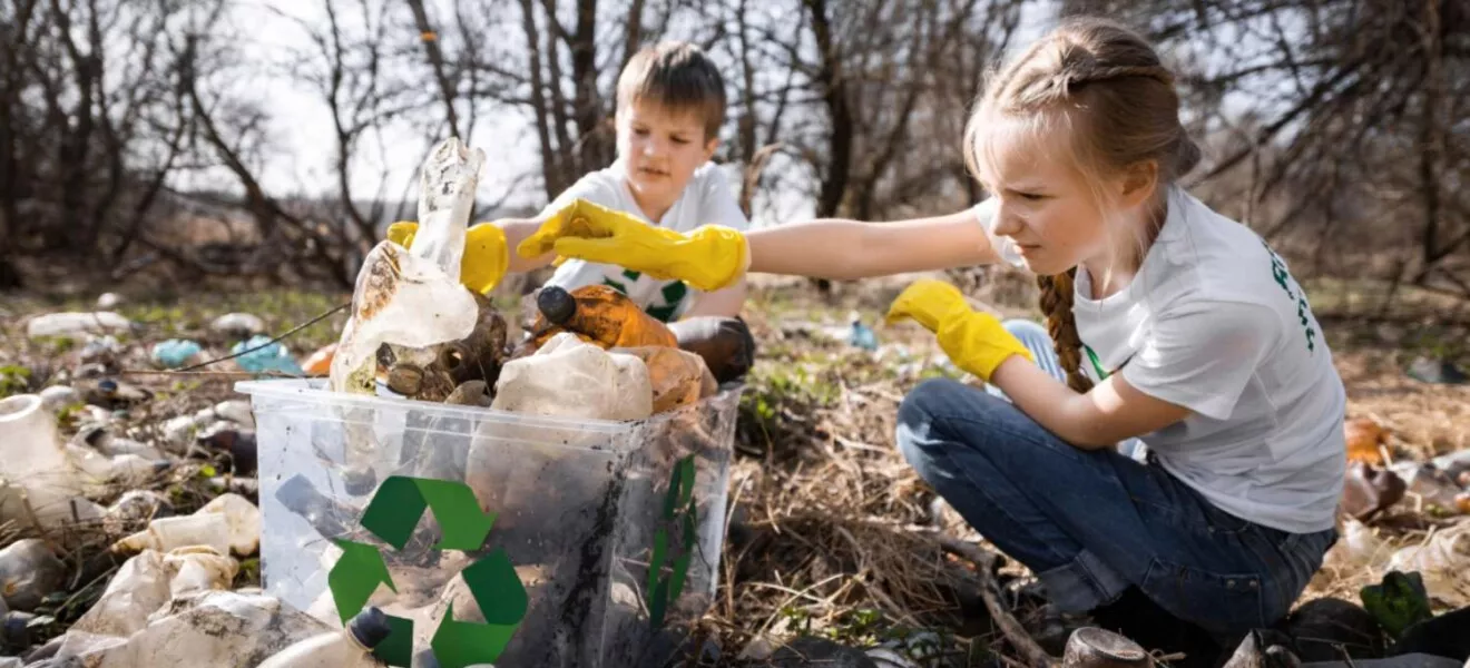 Kinder sammeln Plastikmüll im Wald zur Wiederverwertung und Umweltschutzaktion